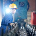 Millwright verifying conveyor in an industrial plant